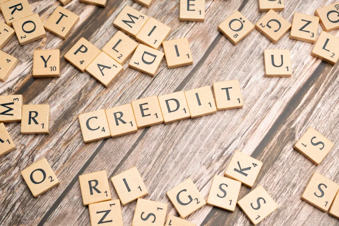 Young person reviewing credit score with student credit card on desk