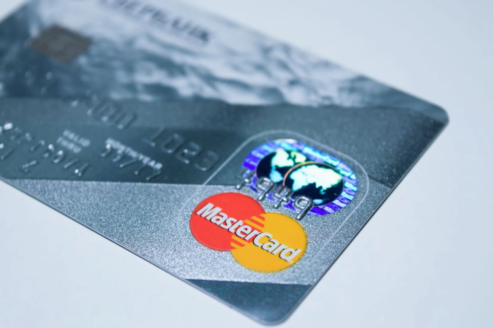Multiple credit cards and bills spread across table showing financial management complexity